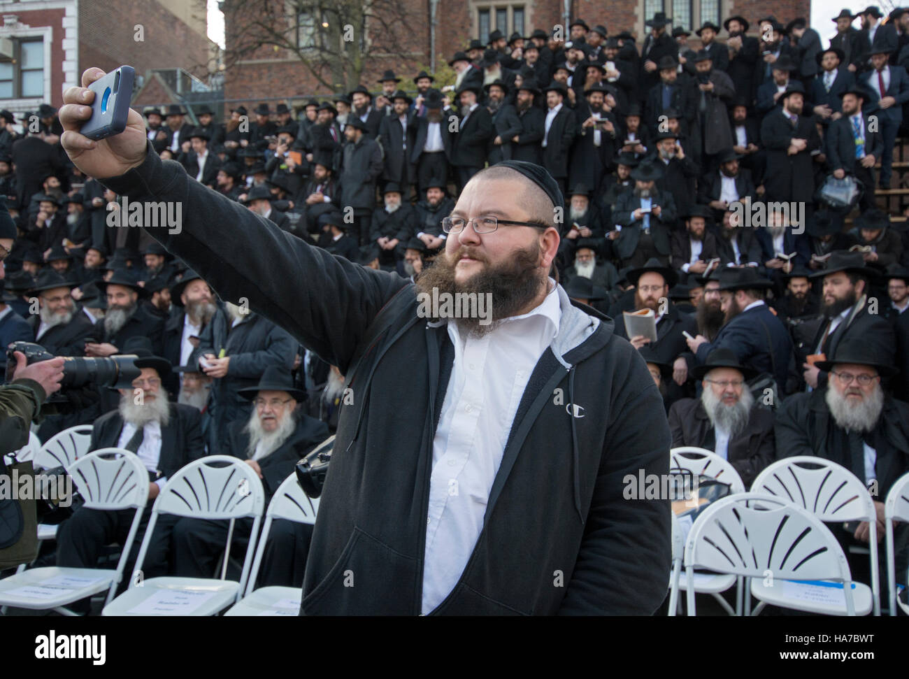 Un ebreo ortodosso uomo prende un selfie davanti a un folto gruppo di Hasidic rabbini si sono riuniti per una foto di gruppo. Brooklyn, New York Foto Stock