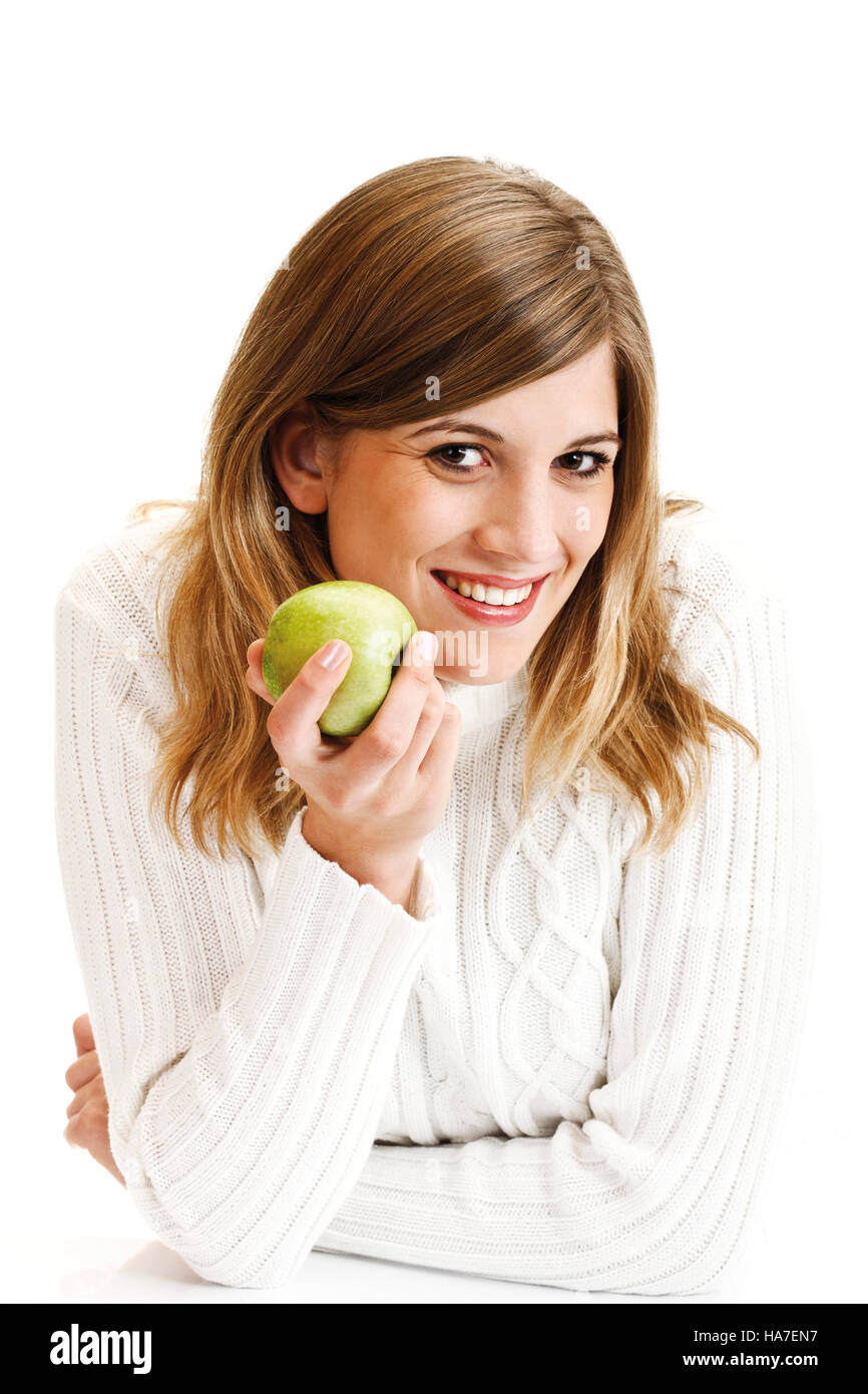 Giovane donna in un bianco maglione turtleneck azienda mela verde Foto  stock - Alamy