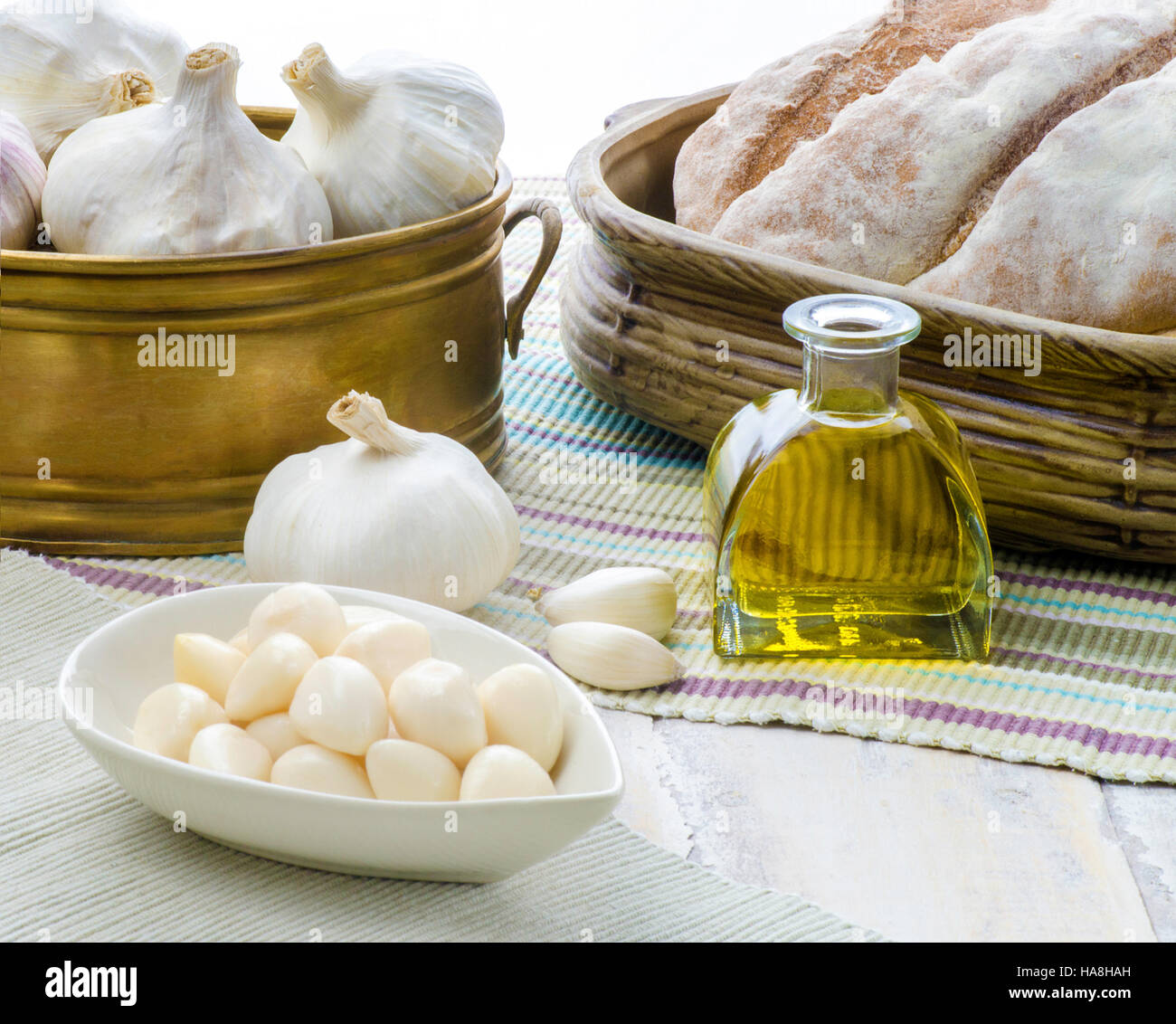 Una disposizione di aglio compresi chiodi di garofano interi e decapati impostato in cucina su un tavolo di legno, spazio copia in basso a destra Foto Stock