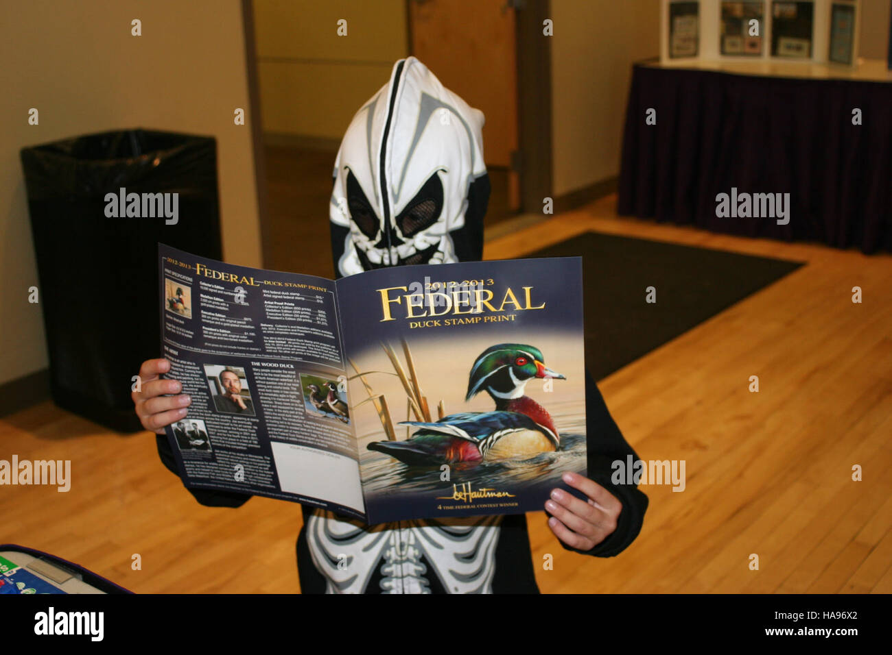 Questa opera d'arte, intitolata "Even Skeletons Love Duck Stamps", combina creativamente figure scheletriche con francobolli d'anatra, mescolando temi di conservazione della fauna selvatica con espressioni artistiche. Sottolinea l'importanza dei francobolli della fauna selvatica nella raccolta fondi e nelle iniziative di sensibilizzazione per la conservazione delle specie. Foto Stock