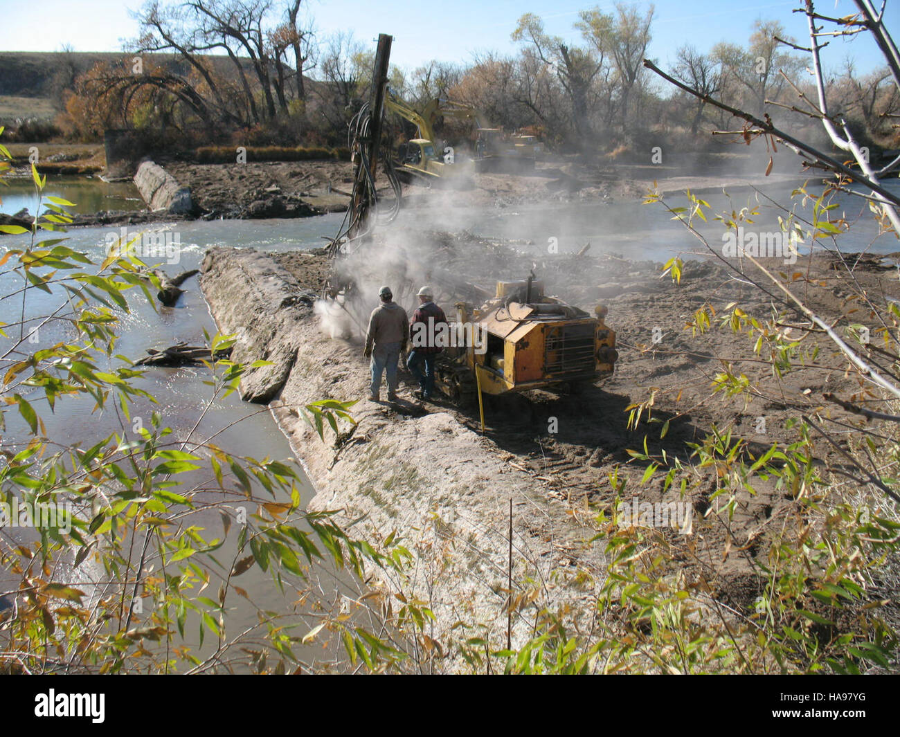Questa immagine mostra un'operazione sul campo in cui viene eseguita la perforazione per posizionare esplosivi per una detonazione controllata. L'operazione fa parte di un più ampio lavoro geologico o ingegneristico, garantendo che gli esplosivi siano posizionati strategicamente per garantire sicurezza ed efficienza. Tali operazioni sono comuni in vari settori, tra cui l'industria mineraria, l'edilizia e le applicazioni militari. Foto Stock