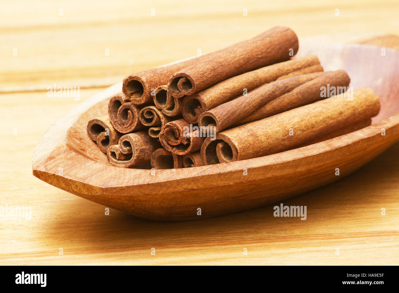 La cannella (Cinnamomum verum) si inceppa in una ciotola di legno Foto Stock