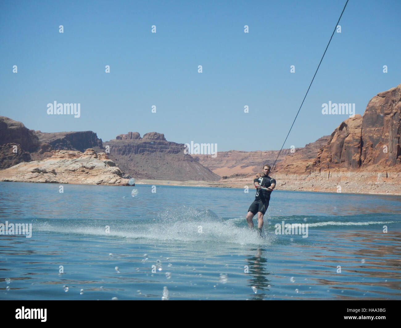 Wakeboard sul lago Powell, Utah, un'attività molto popolare tra i visitatori dell'area ricreativa nazionale del Glen Canyon. Il lago, formato dalla diga del Glen Canyon, offre attività ricreative e sport acquatici in un paesaggio desertico panoramico. Foto Stock