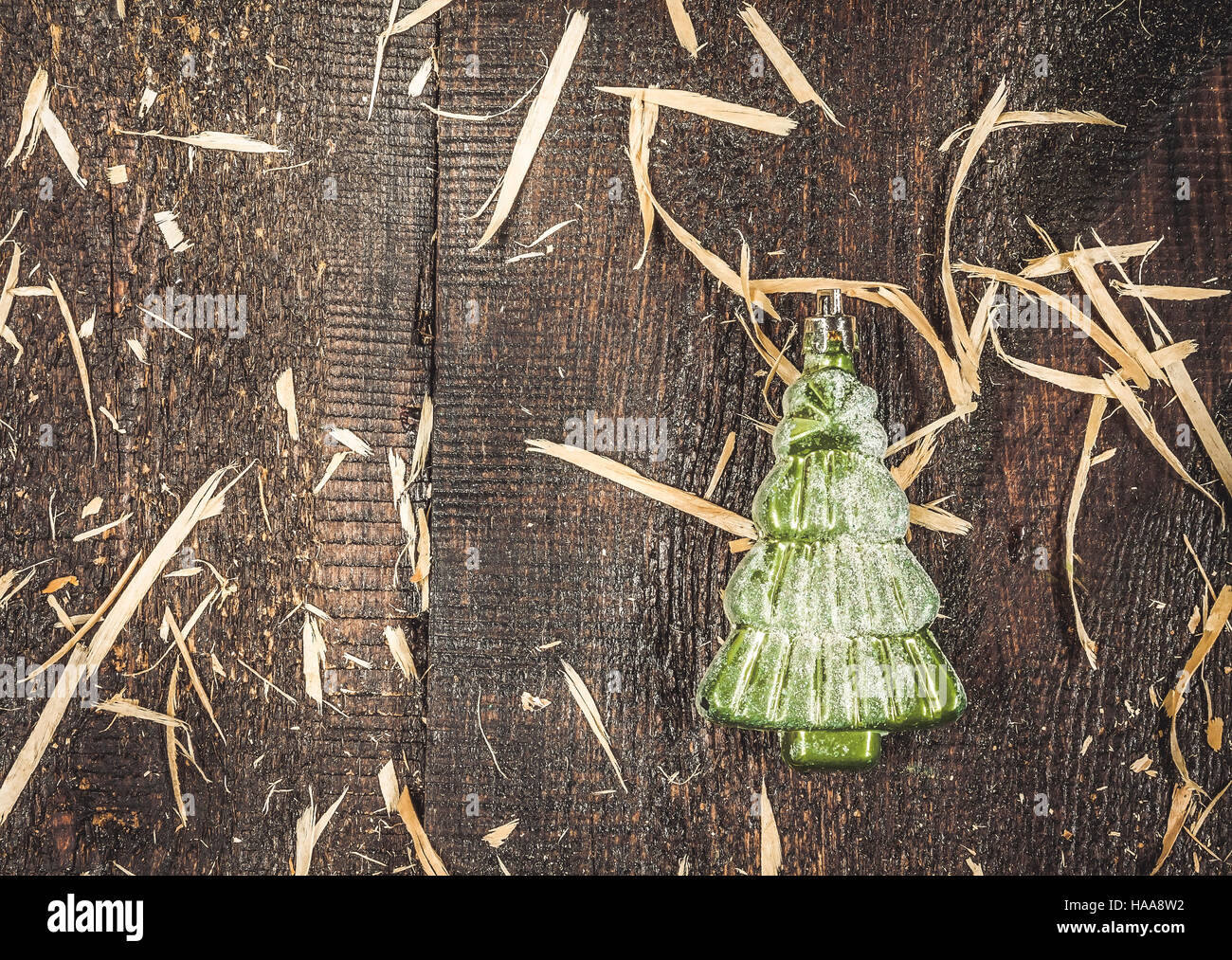 Natale di vetro-tree giocattolo in forma di abete di neve su un rustico in legno scuro dello sfondo. Foto Stock