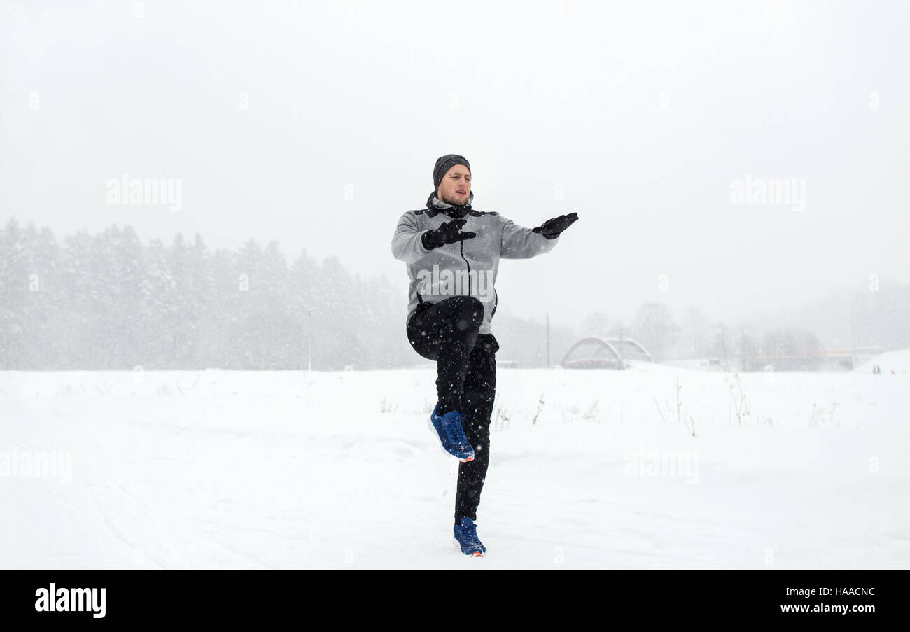 L'uomo esercita e warmig fino in inverno all'aperto Foto Stock