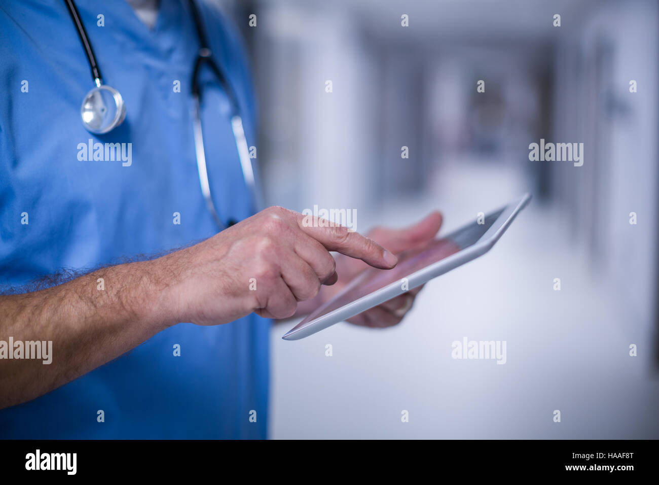 Chirurgo maschio utilizzando digitale compressa nella camera operativa Foto Stock