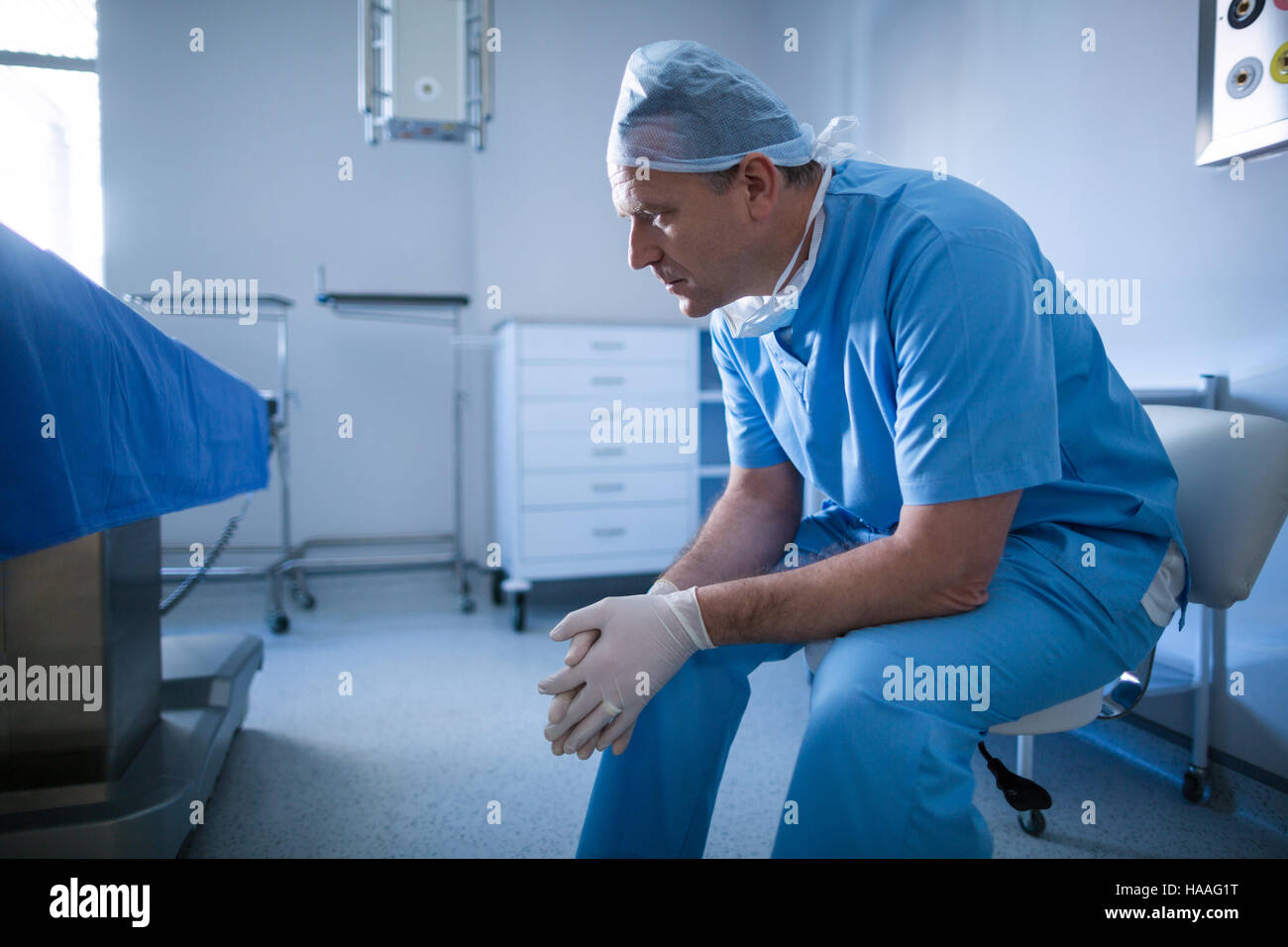Chirurgo maschile seduto su una sedia Foto Stock