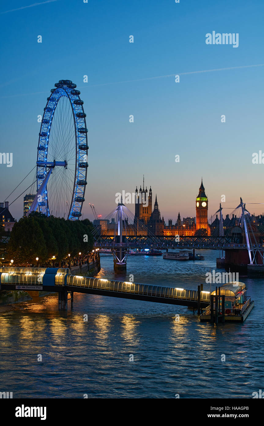 Il London Eye e Westminster al tramonto, con Festival molo sul Tamigi Foto Stock