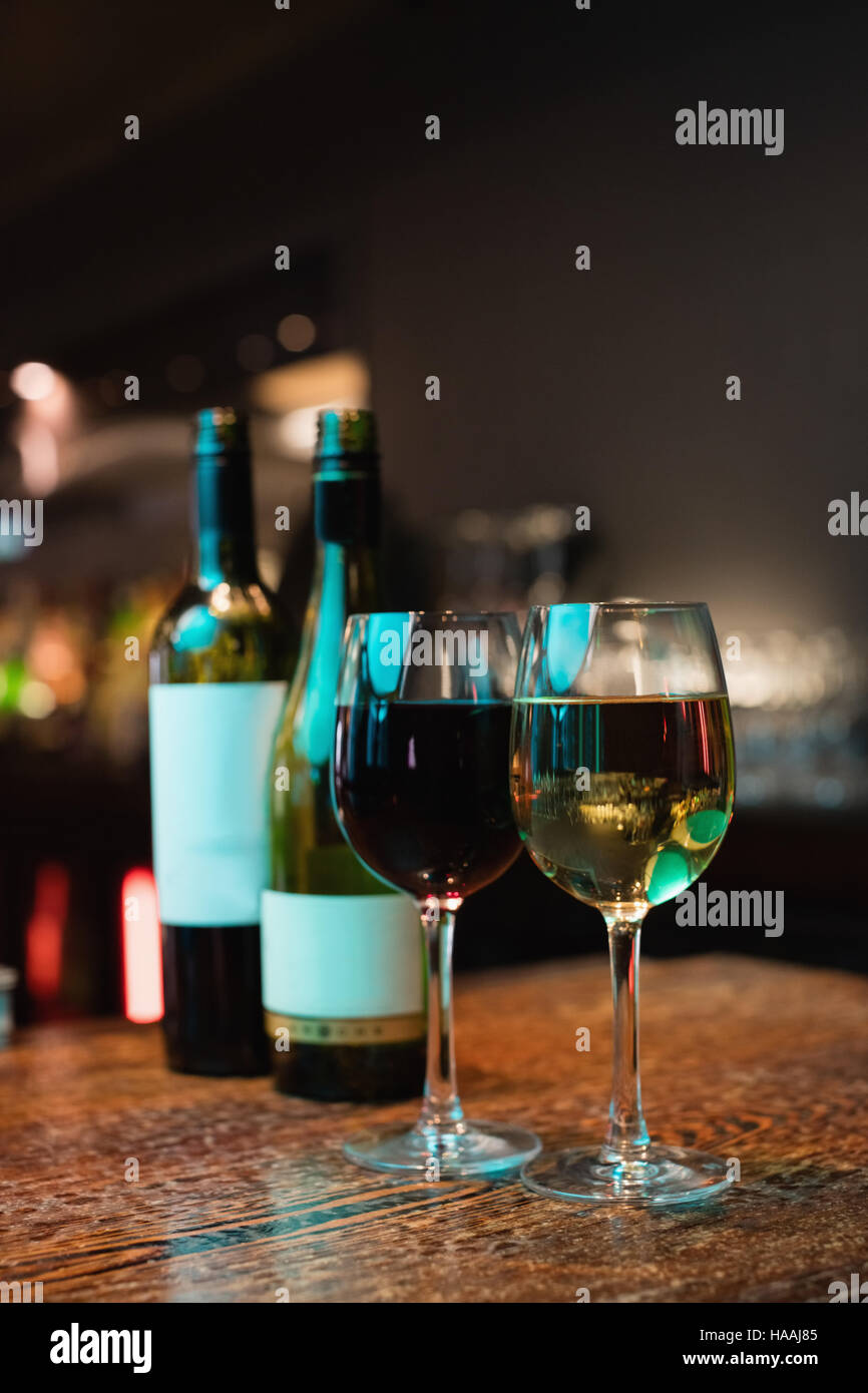 Bicchieri di vino rosso e bottiglie sul bancone bar Foto stock - Alamy