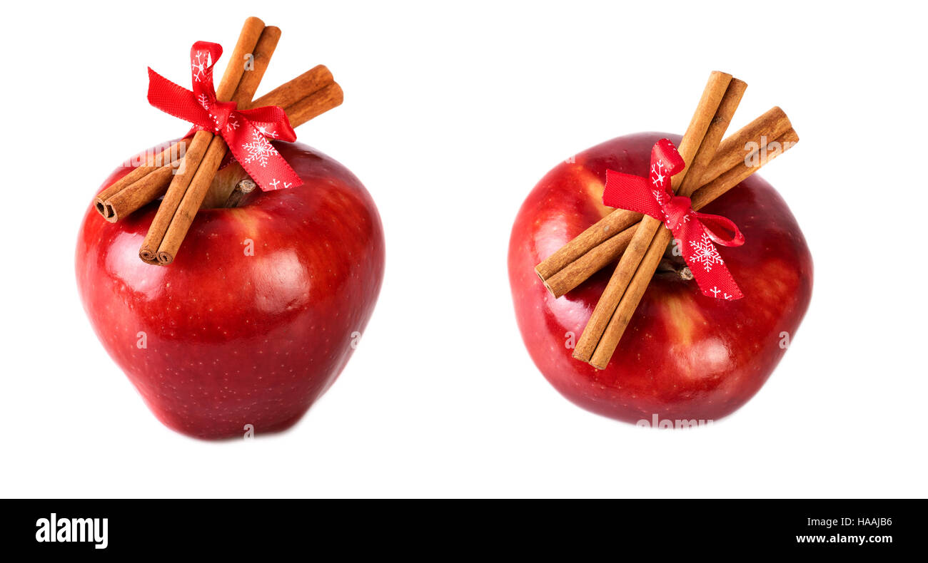 Rosso brillante mele Natale decorato con bastoncini di cannella su sfondo bianco Foto Stock