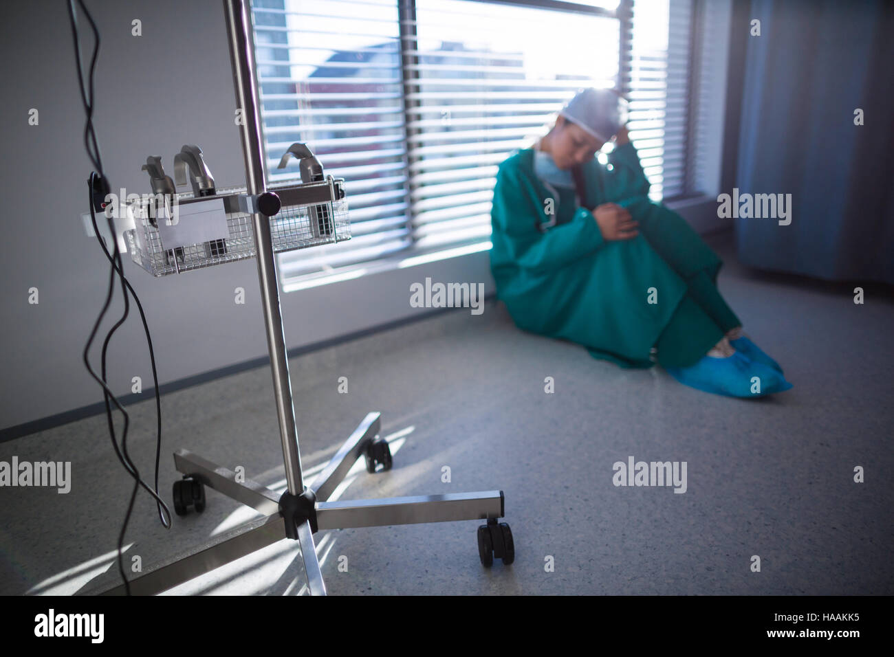 Teso chirurgo femmina seduto in corridoio Foto Stock