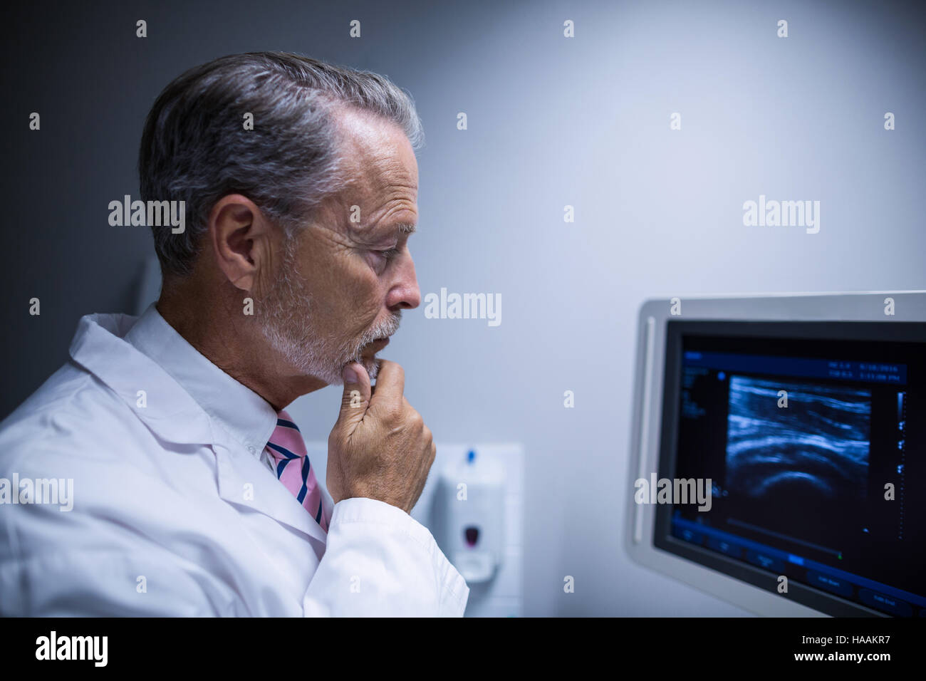 Chirurgo guardando il dispositivo ad ultrasuoni macchina Foto Stock