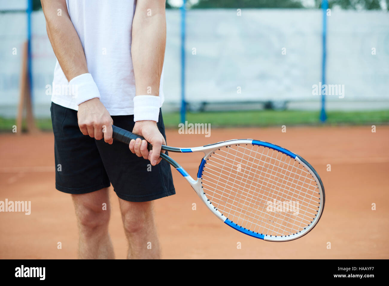 L'uomo è in possesso di una racchetta da tennis Foto Stock