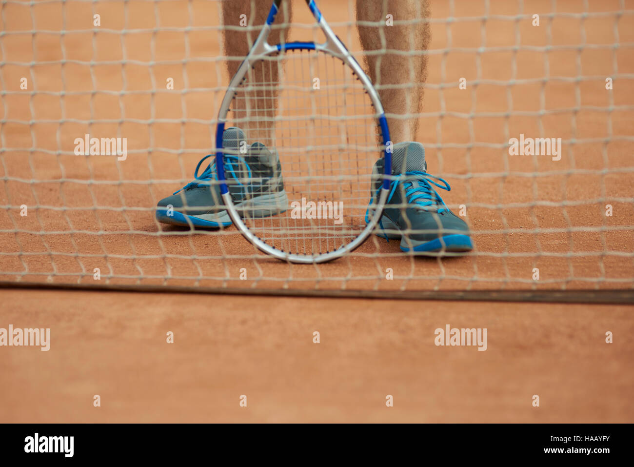 Il giocatore è in piedi dietro il tennis net Foto Stock