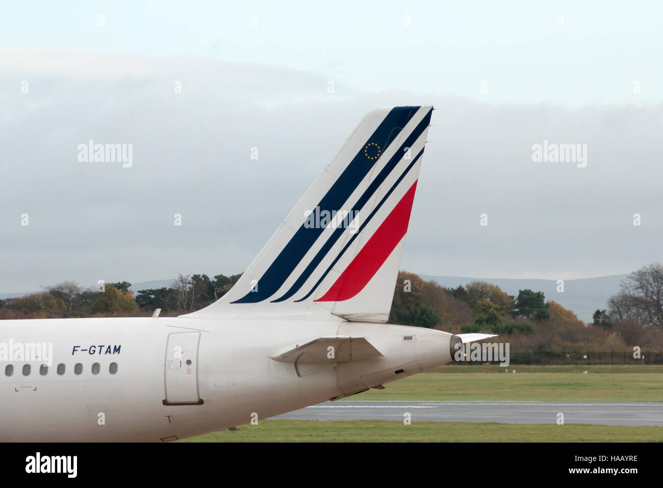 Air France Airbus A321-212 corpo stretto piano passeggero (F-GTAM) verticale stabilizzatore, l'Aeroporto Internazionale di Manchester asfalto. Foto Stock