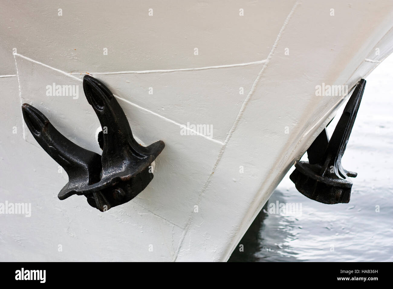 Due ancore nero su bianco dipinto di prua di una nave in porto Foto Stock