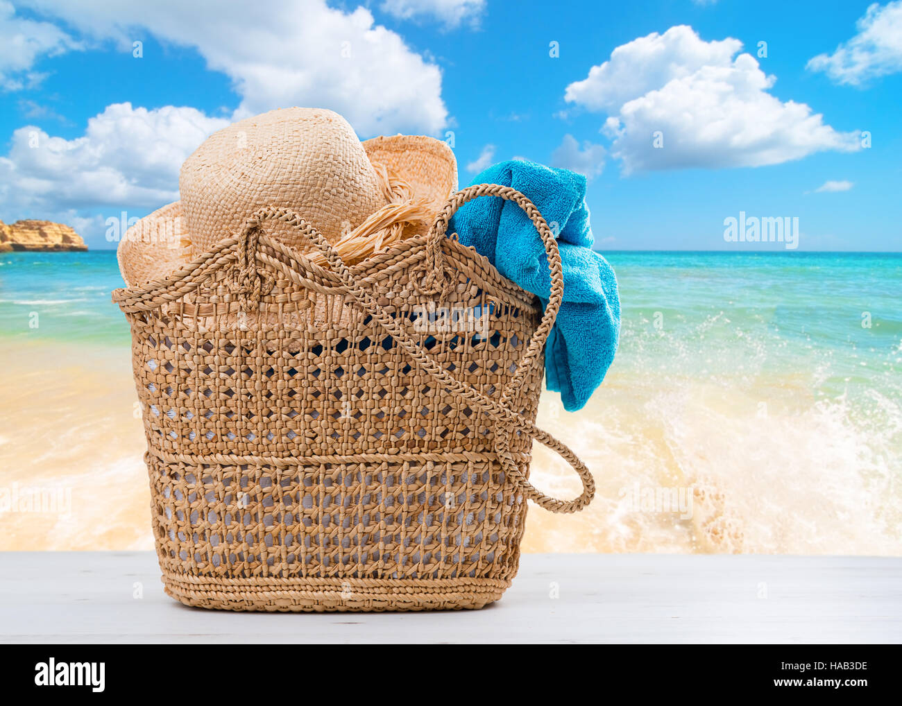 Beach basket impaccata con asciugamano e cappello con spiaggia blur sullo  sfondo Foto stock - Alamy