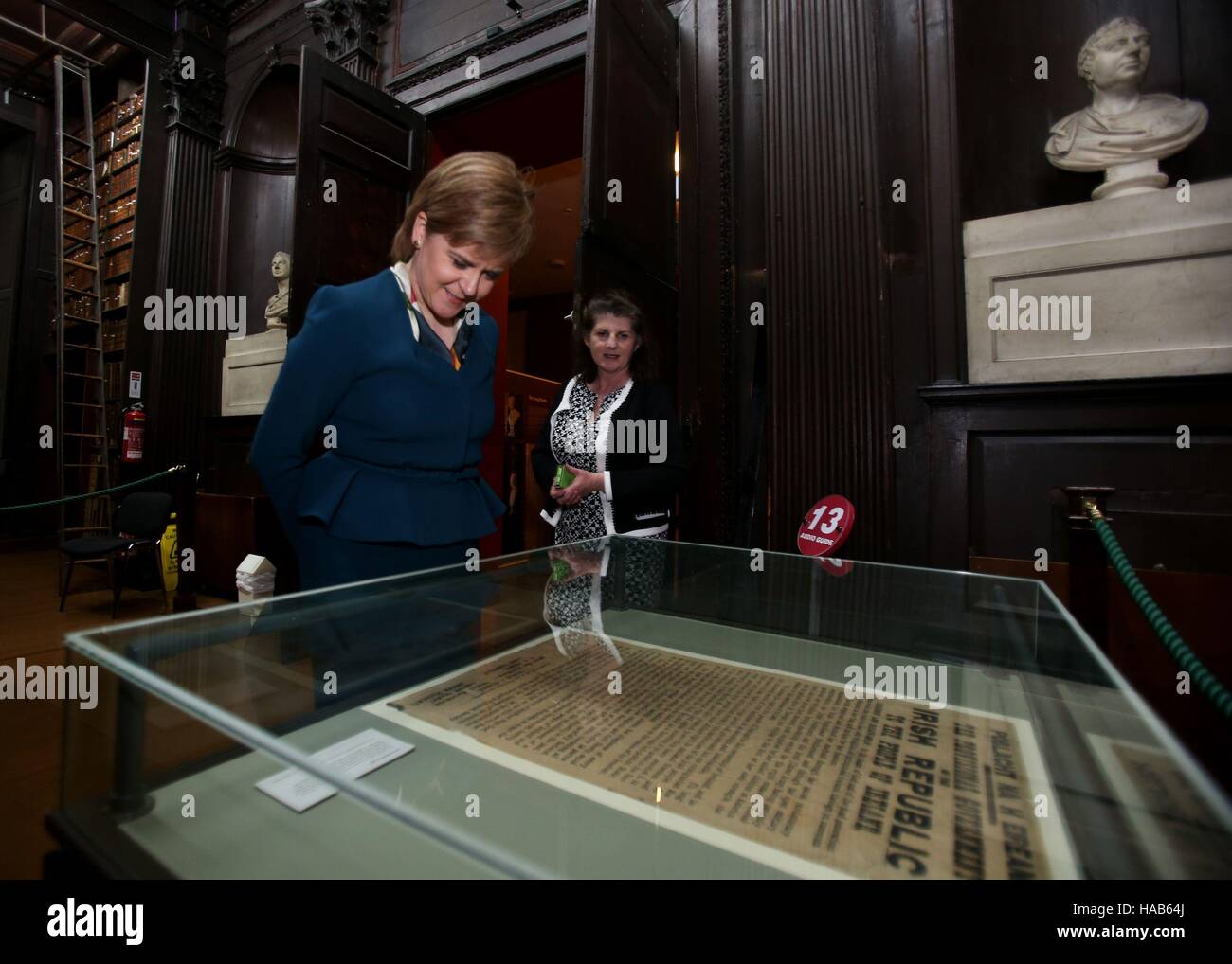 Scottish Primo Ministro Nicola storione e bibliotecario Anne-Marie Diffley guardare una copia originale della Irish proclamazione di indipendenza di una scatola di vetro nella biblioteca presso il Trinity College di Dublino. Foto Stock