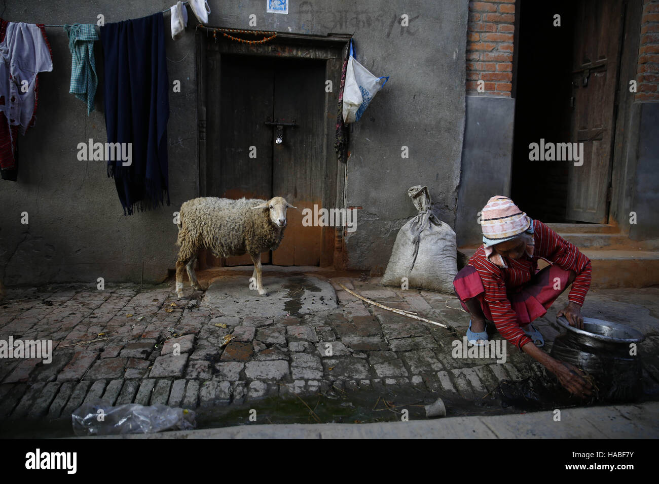 Lalitpur, Nepal. 29 Nov, 2016. Una donna Nepalese facendo la sua attività da fare in un vicolo nel villaggio Khokana, Lalitpur, Nepal Martedì, Novembre 29, 2016. © Skanda Gautam/ZUMA filo/Alamy Live News Foto Stock