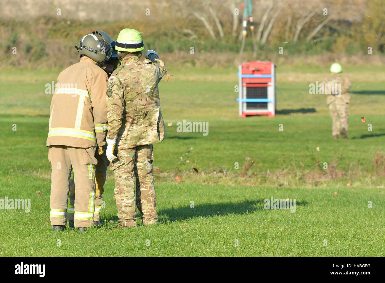 RAF Chinook sollevamento di un elevato volume di pompa dal Sandown aeroporto sull'Isola di Wight durante un multi-agenzia esercizio di formazione. Vigili del fuoco guardando su prima di prendere in consegna e farlo loro stessi Foto Stock
