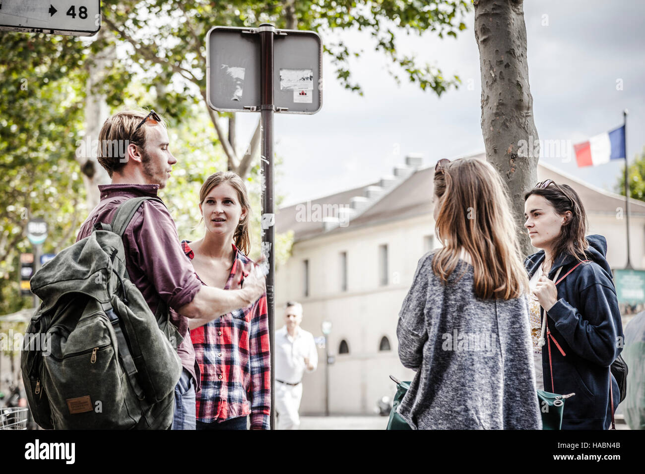 Happy amici di parlare tenendo una conversazione per le strade di Parigi Foto Stock