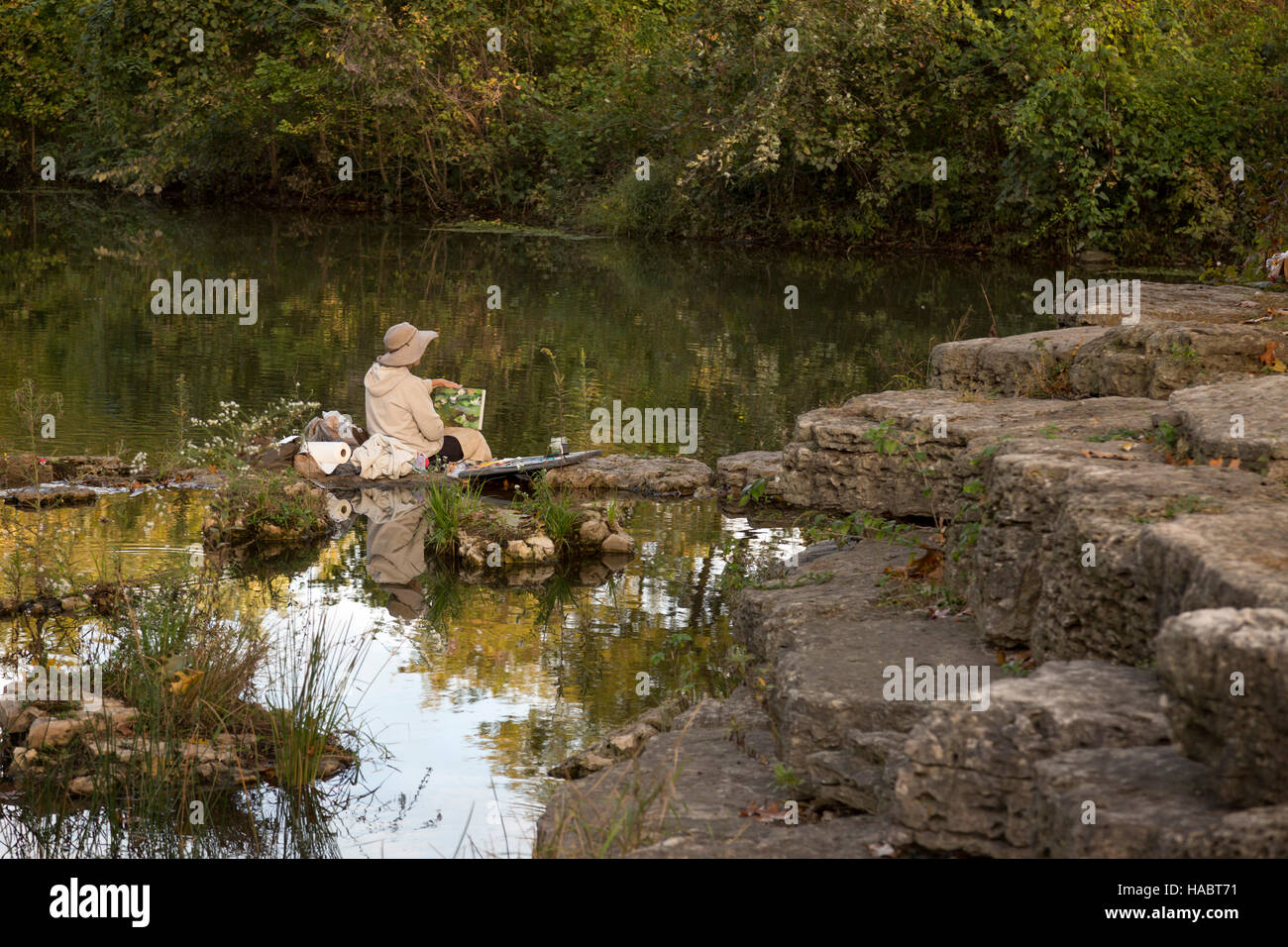 Senior donna artista, pittura al fresco, sulle sponde di un lago. Louis, Missouri, Forest Park. Foto Stock