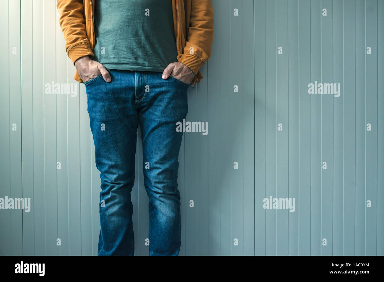 Tall irriconoscibile uomo informale in jeans in posa, parete come spazio di copia Foto Stock