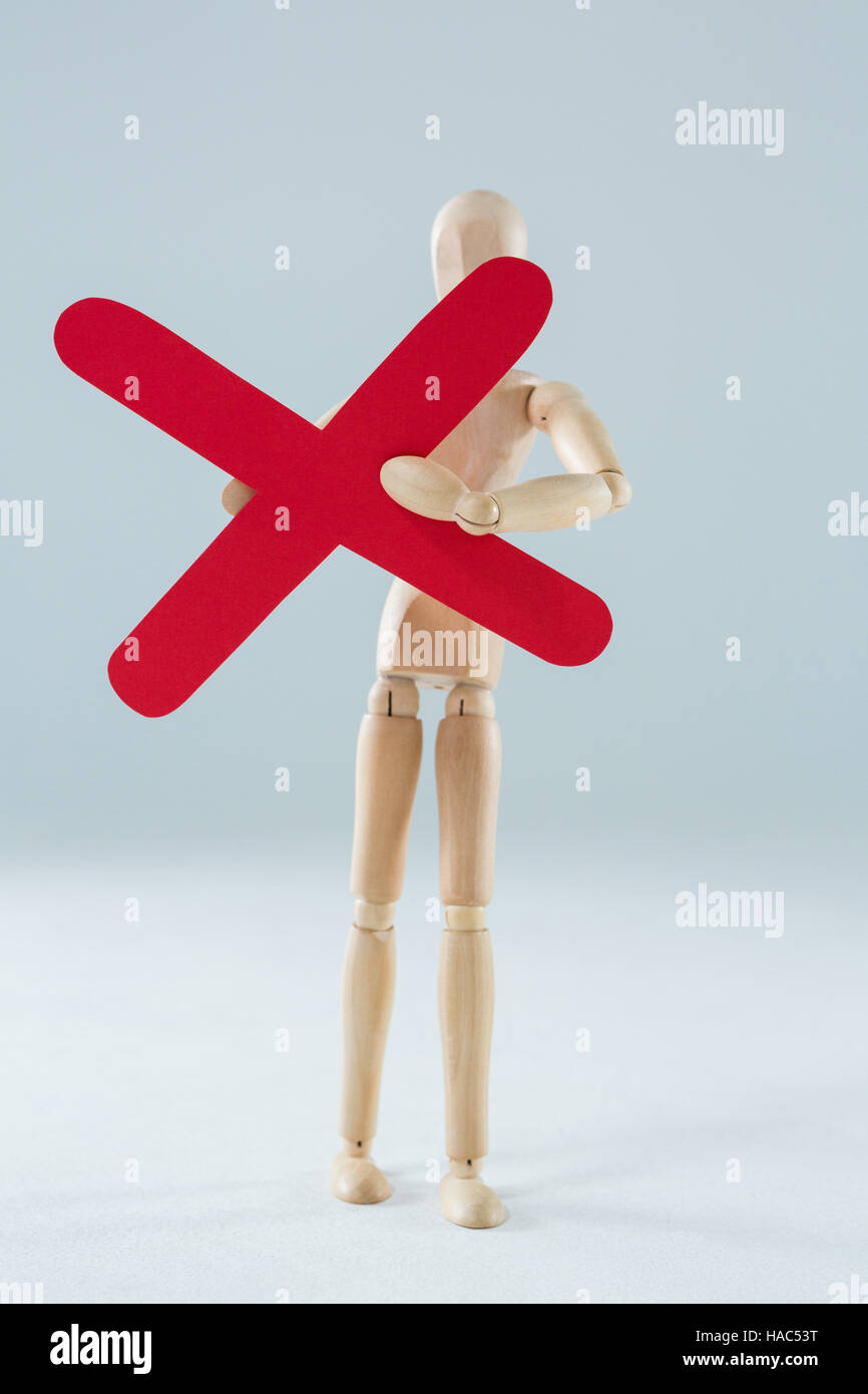 Statuetta di legno tenendo premuto segno di moltiplicazione Foto Stock