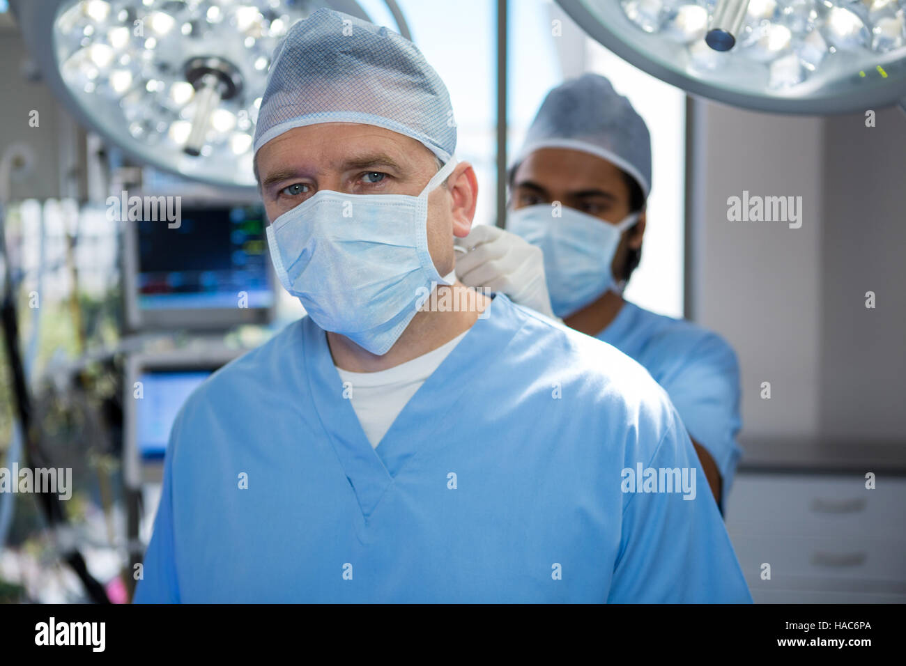 Chirurgo aiutando nella legatura di ossigeno nella camera di funzionamento Foto Stock