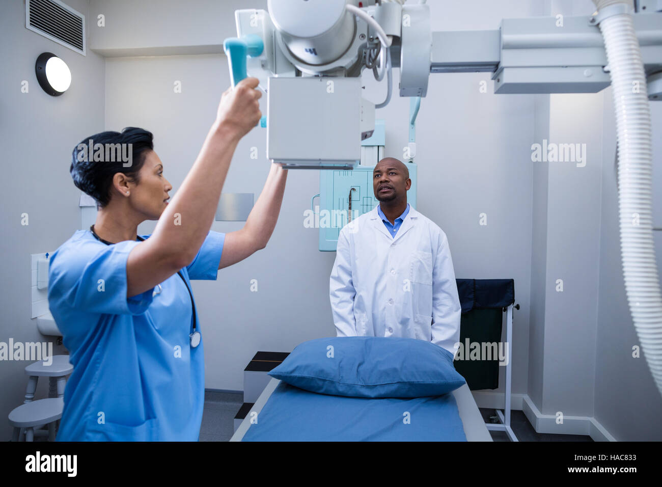 L'infermiera che interagiscono con il medico durante la regolazione della macchina medica Foto Stock