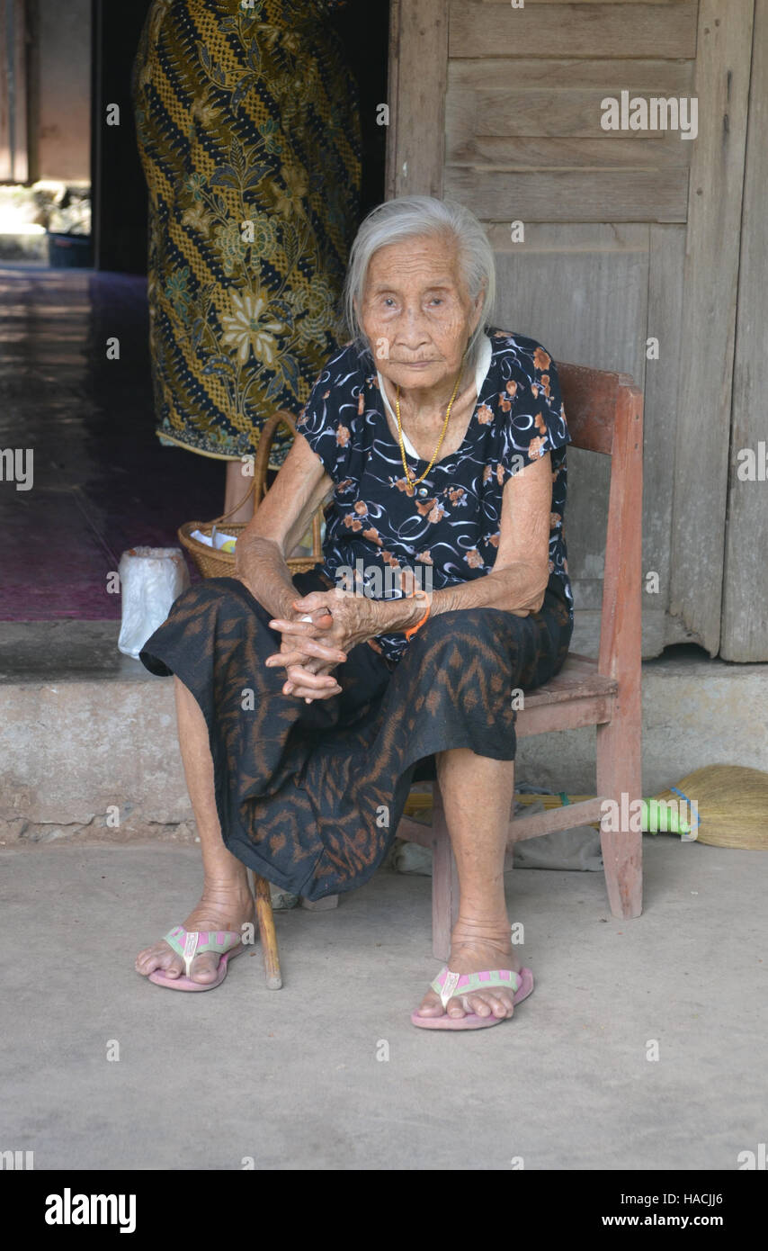 Anziani donna asiatica seduto fuori Foto Stock