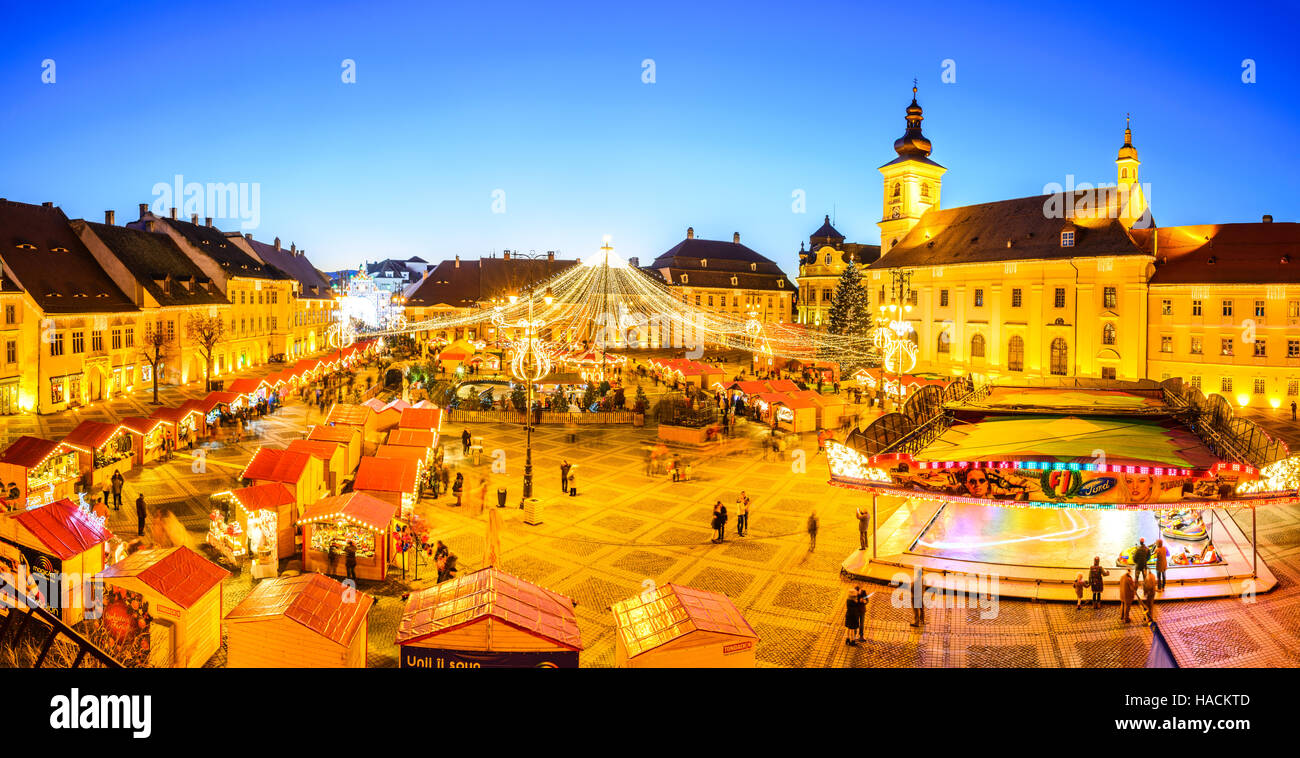 Sibiu, Romania. Immagine di notte con i turisti al mercatino di Natale nel grande mercato medievale di Sibiu, Transilvania landmark. Foto Stock