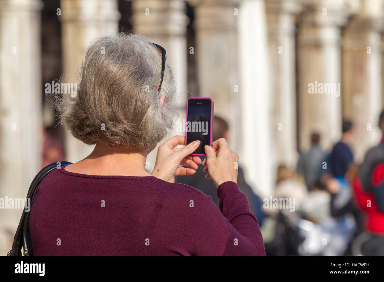 Le donne che prendono le foto sul suo telefono cellulare, in Piazza San Marco, Venezia, Italia. Foto Stock