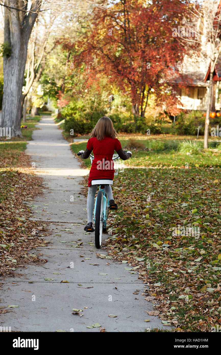 Dieci anni di equitazione ragazza il suo vintage bici sul marciapiede. Minneapolis, MN, l'autunno. Modello di rilascio:Ellie Brown Foto Stock