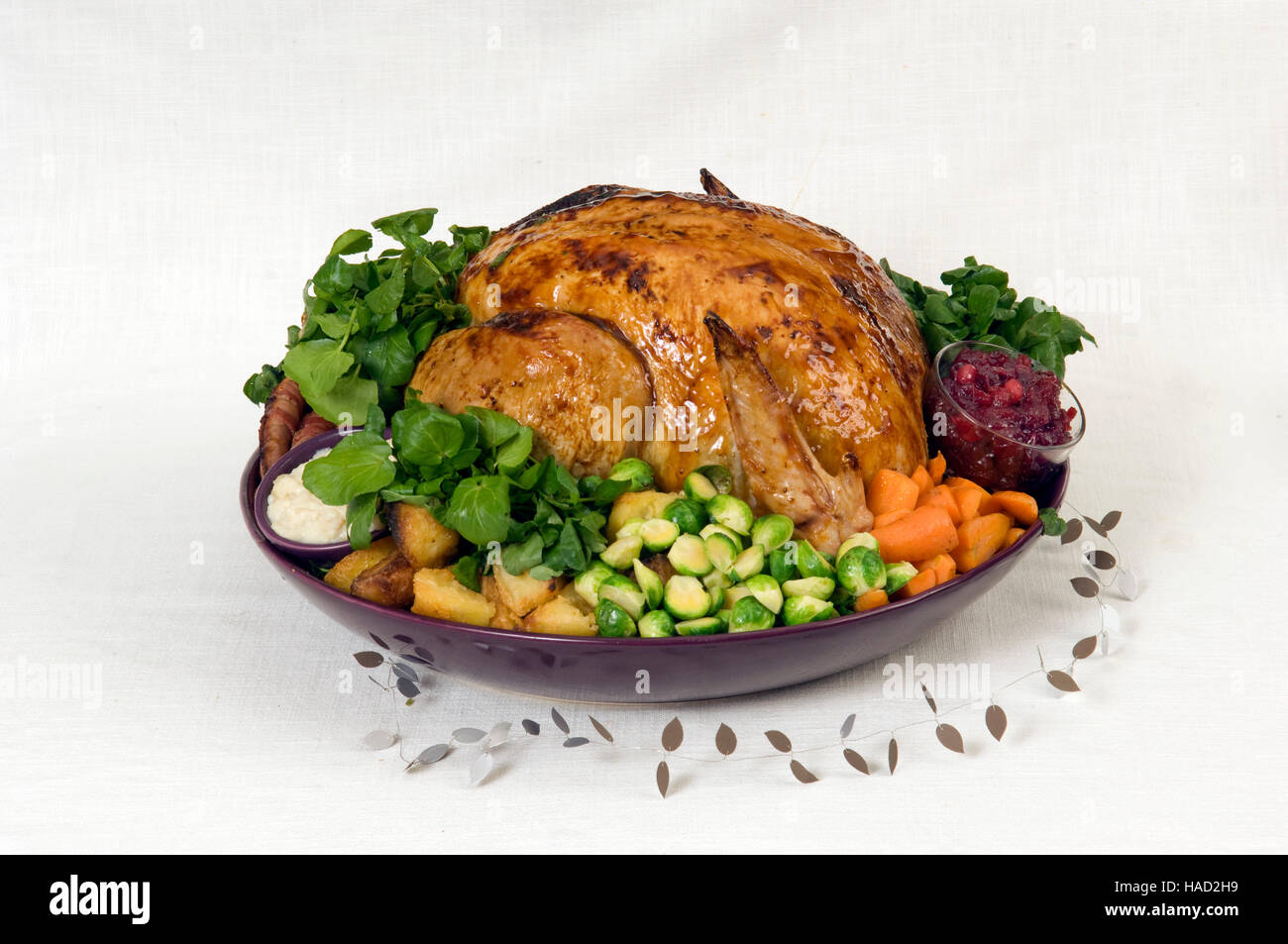 Un arrosto di tacchino di Natale completo con i cavoli di Bruxelles, patate arrosto, le carote e il ripieno in un grande piatto rotondo.Un REGNO UNITO Foto Stock