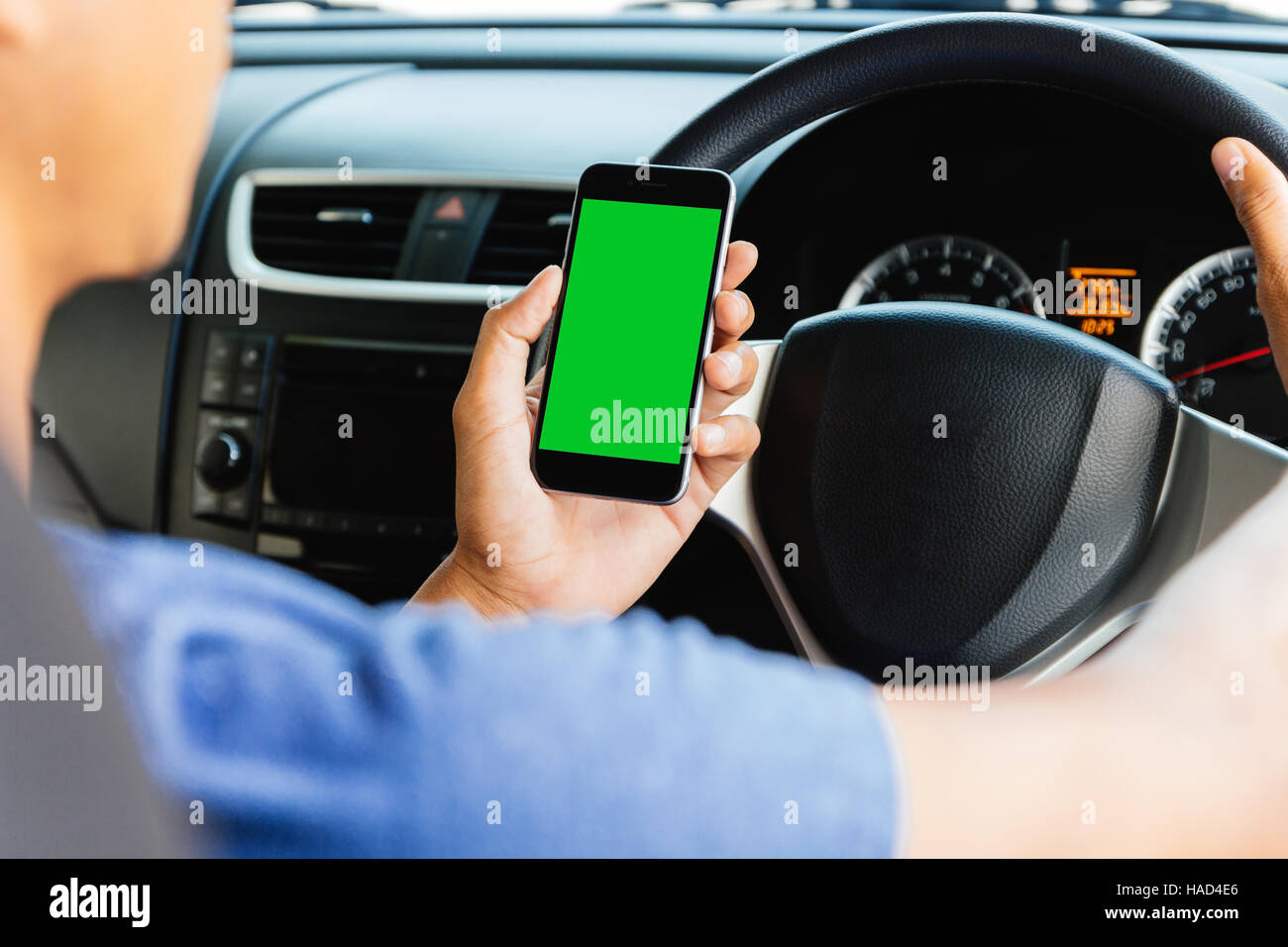 L'uomo utilizzando l'applicazione Mappe sul telefono cellulare in auto, telefono con schermo verde facile per la regolazione Foto Stock