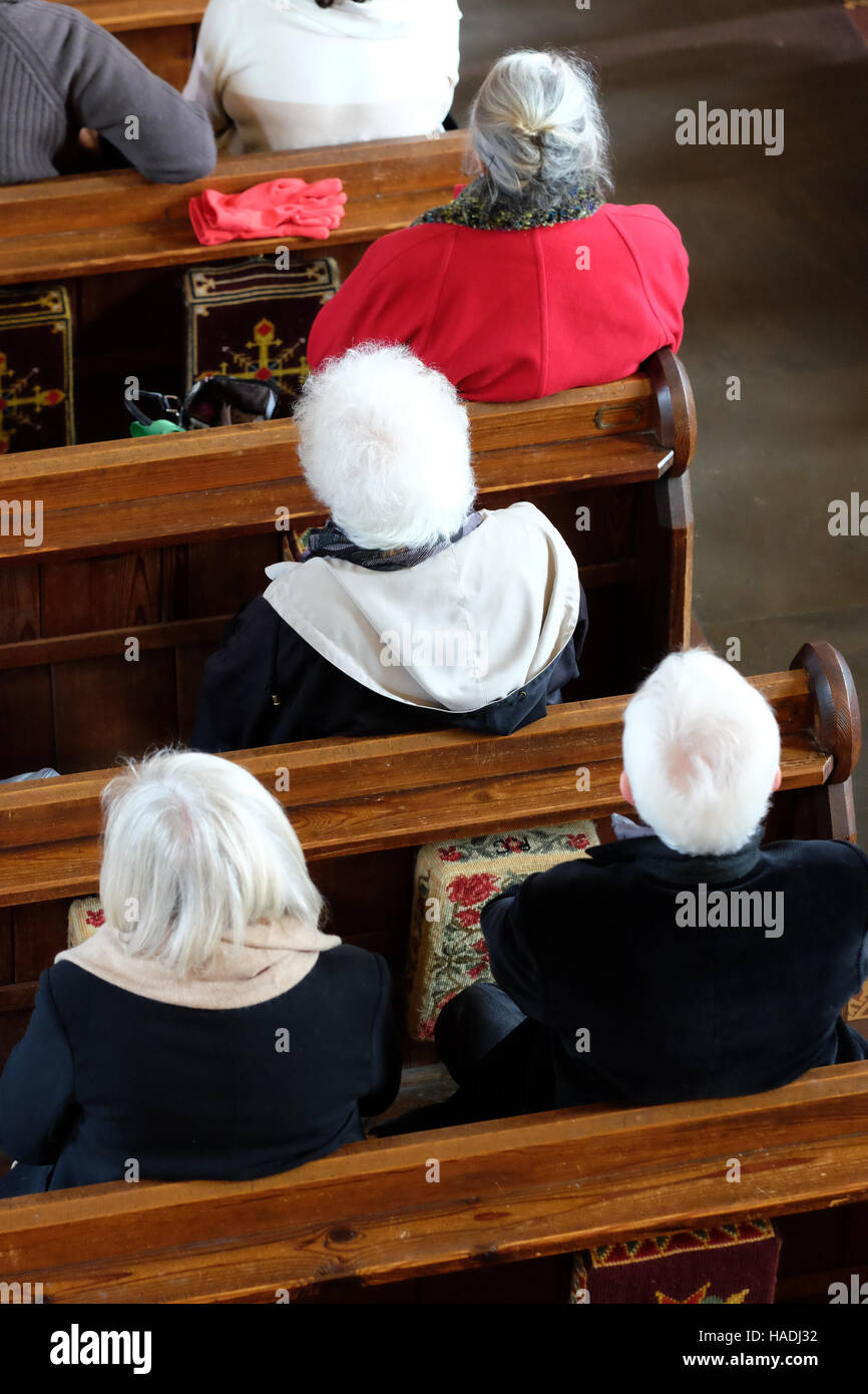 Herefordshire, Regno Unito vecchie persone mature frequentare un servizio di chiesa e sedersi nella congregazione. Foto Stock
