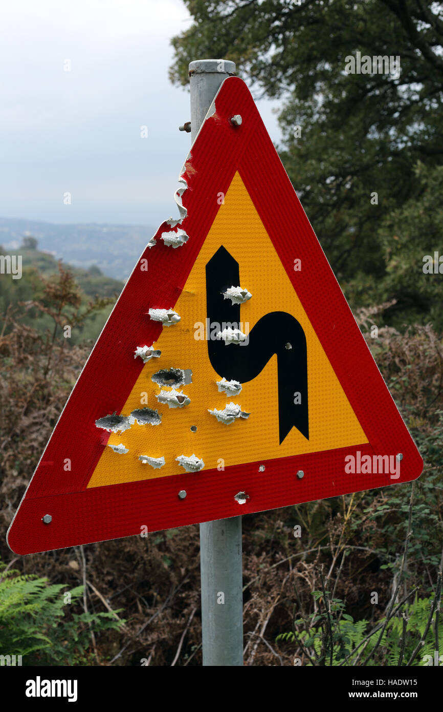 Un nuovo pericolo segno di avvertimento su una strada di montagna in Creta, Grecia, che è stato condito con proiettili dalla pistola-crazy locali. Le indicazioni stradali sono frequentemente utilizzati Foto Stock