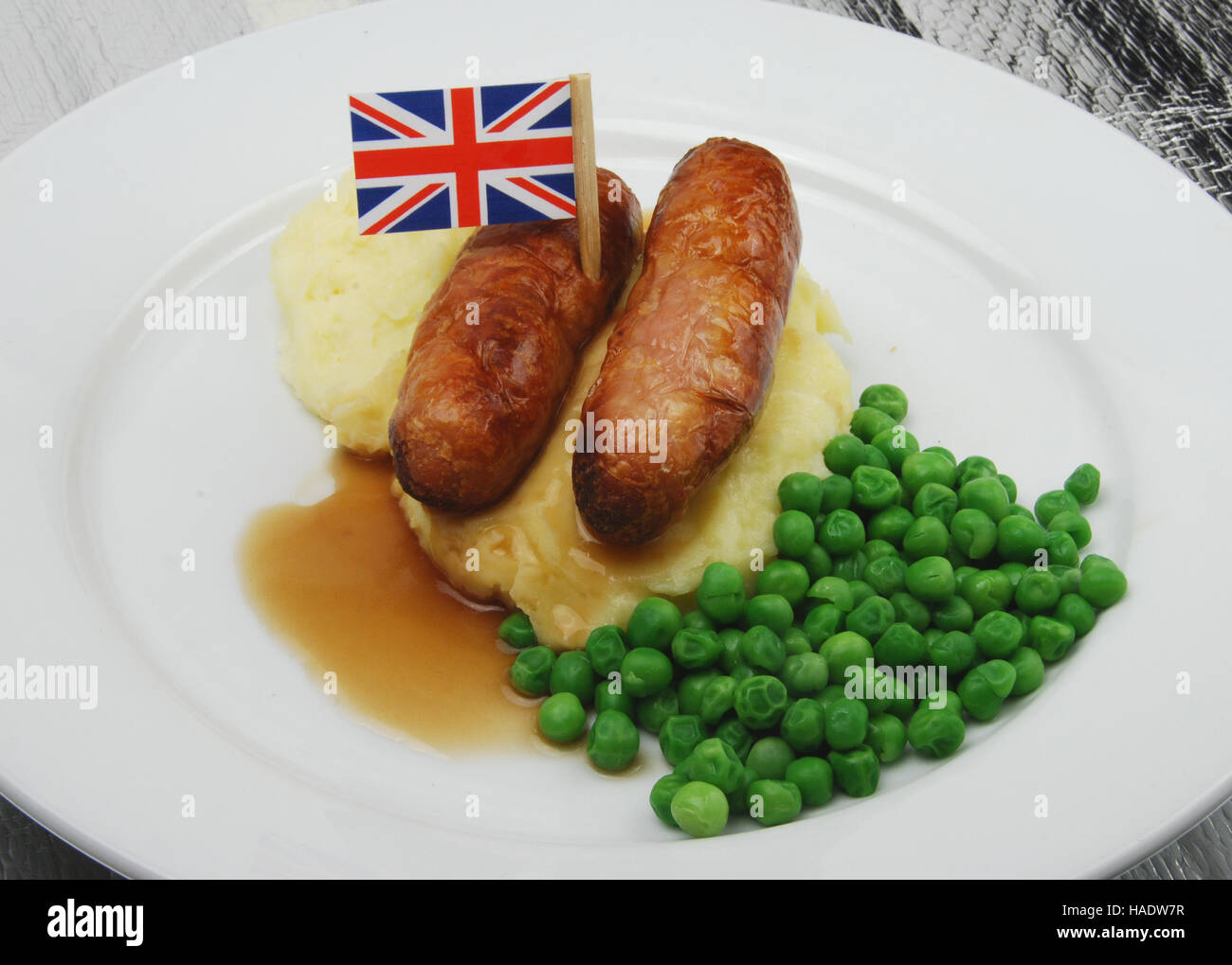 British salsiccia e mash con piselli e sugo di carne che mostra la bandiera europea Foto Stock