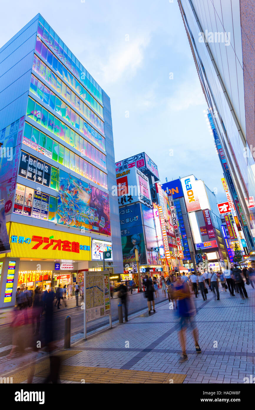 La folla della vivace città di gente che cammina intorno al mozzo di elettronica quartiere di Akihabara tra luci brillanti e memorizzare i segni, advertis Foto Stock