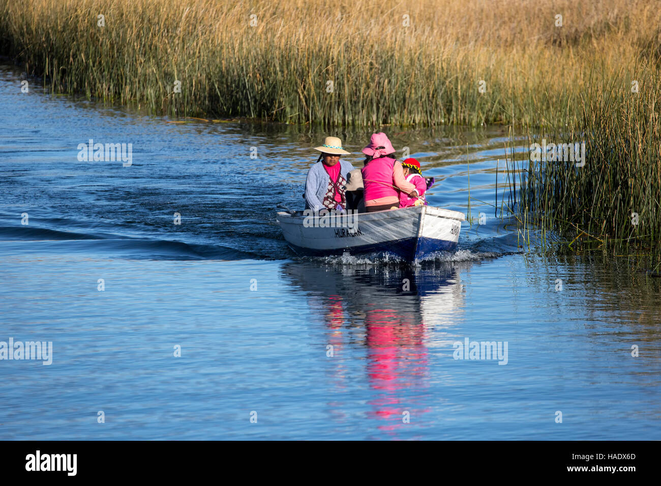 Uros persone in barca nei pressi di totora reeds campo, il lago Titicaca, Puno, Perù Foto Stock