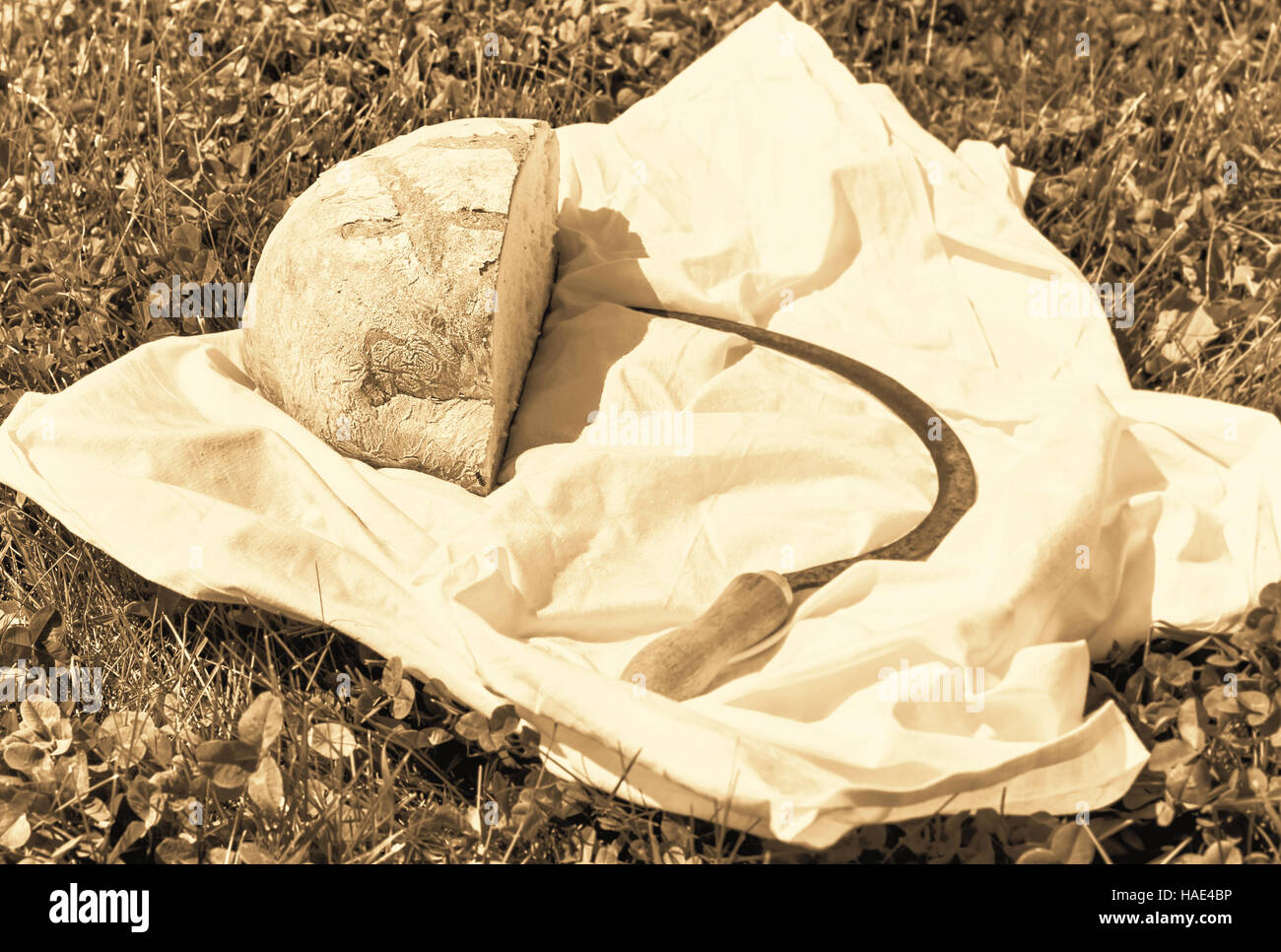 Filone di pane e un martello in estate di erba a seppia Foto Stock