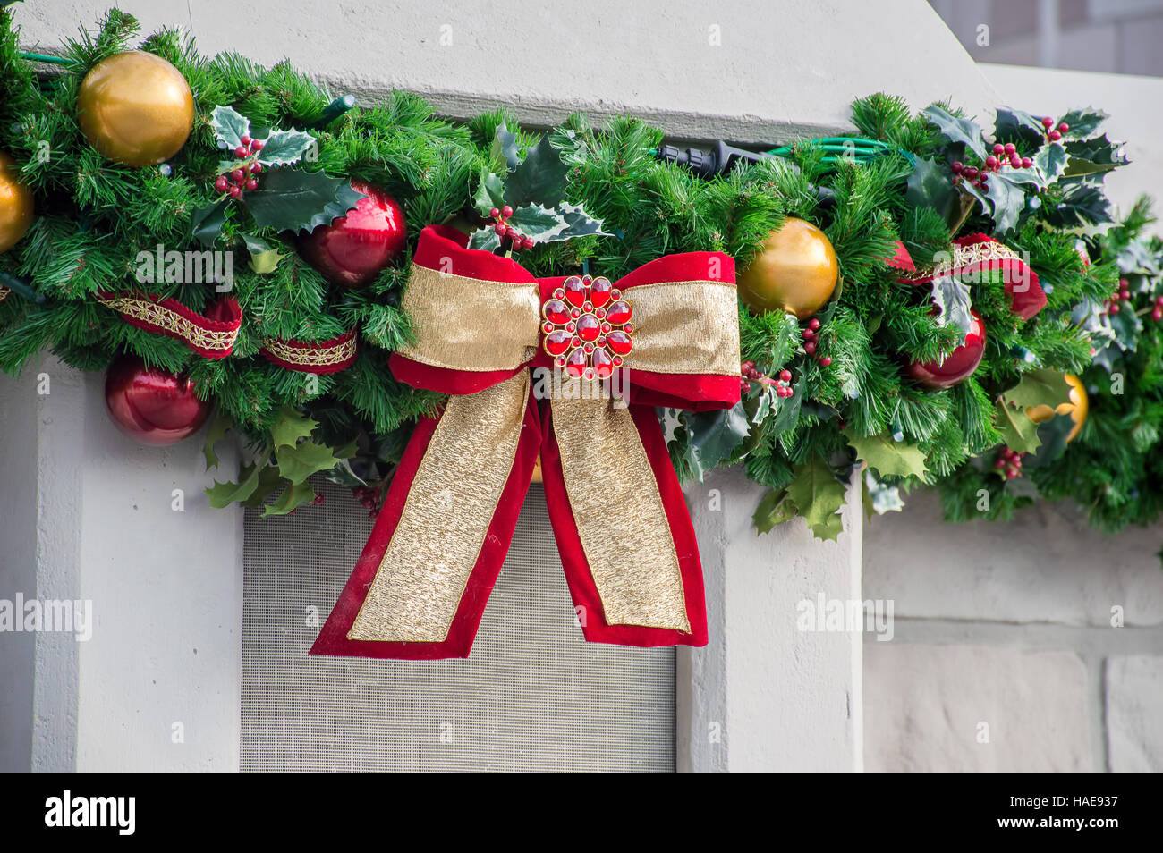 Una sezione di una ghirlanda di Natale con un grande rosso e oro prua. Foto Stock