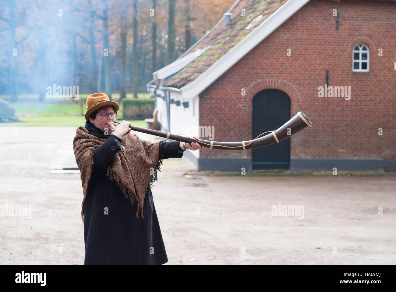 OLDENZAAL, Paesi Bassi - 27 novembre 2016: donna sconosciuta a soffiare una cosiddetta 'midwinterhorn', un tradizionale in legno fatti a mano instument. Esso è utilizzato in Foto Stock