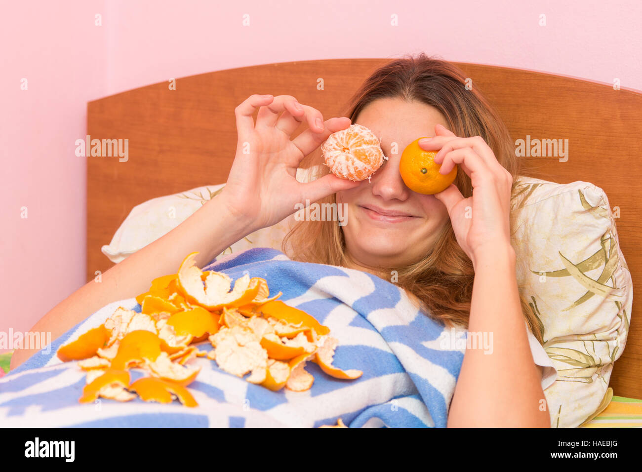 Felice donna divertente mettere i tangerini per gli occhi Foto Stock