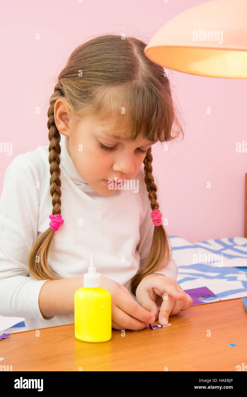 La ragazza bastoni un piccolo inchino di carta colorata Foto Stock