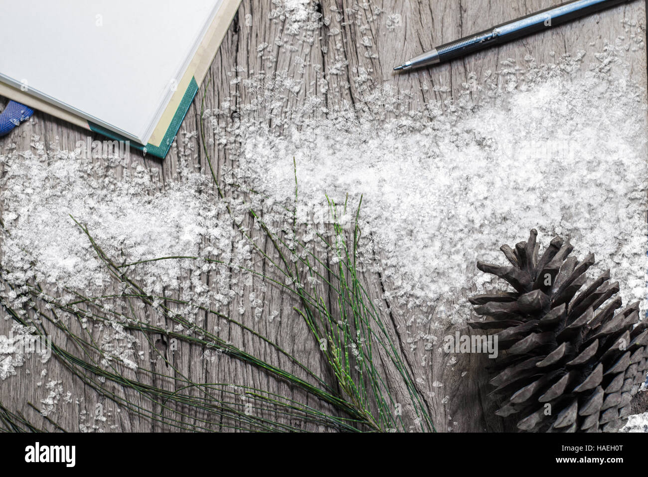 Snow ice note book con matita e pigne sul vecchio legno Natale sfondo Foto Stock