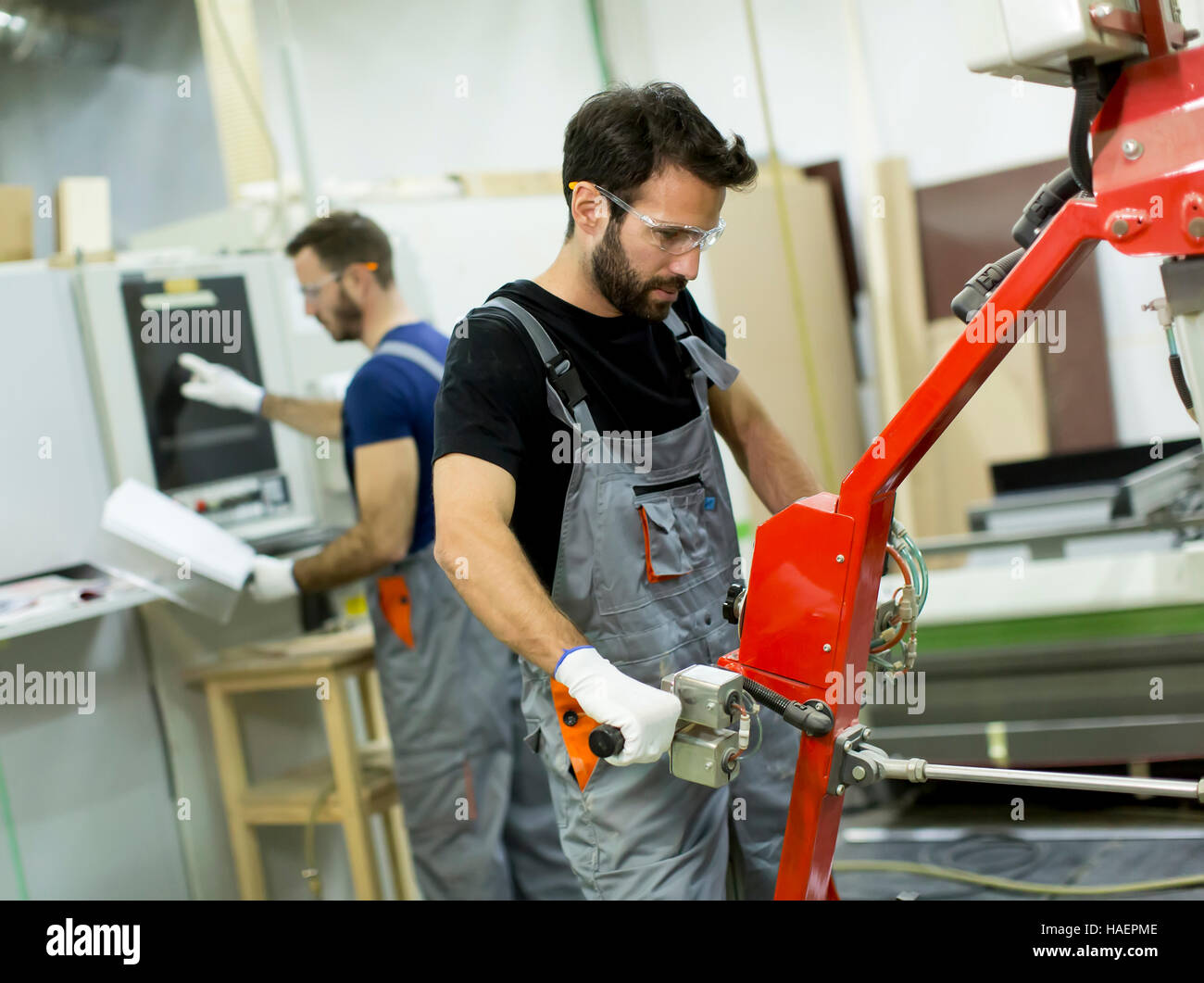 Giovani uomini che lavorano in una fabbrica per la produzione di mobili Foto Stock