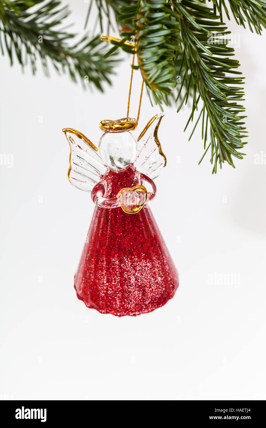 Vetro rosso angelo su un Fraser Abete albero di Natale tenendo un cuore Foto Stock