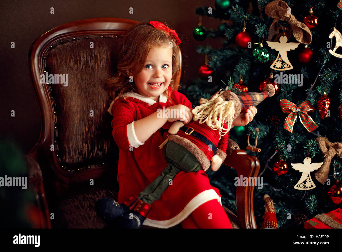 Ridere piccola ragazza con una decorazione di Santa Foto Stock
